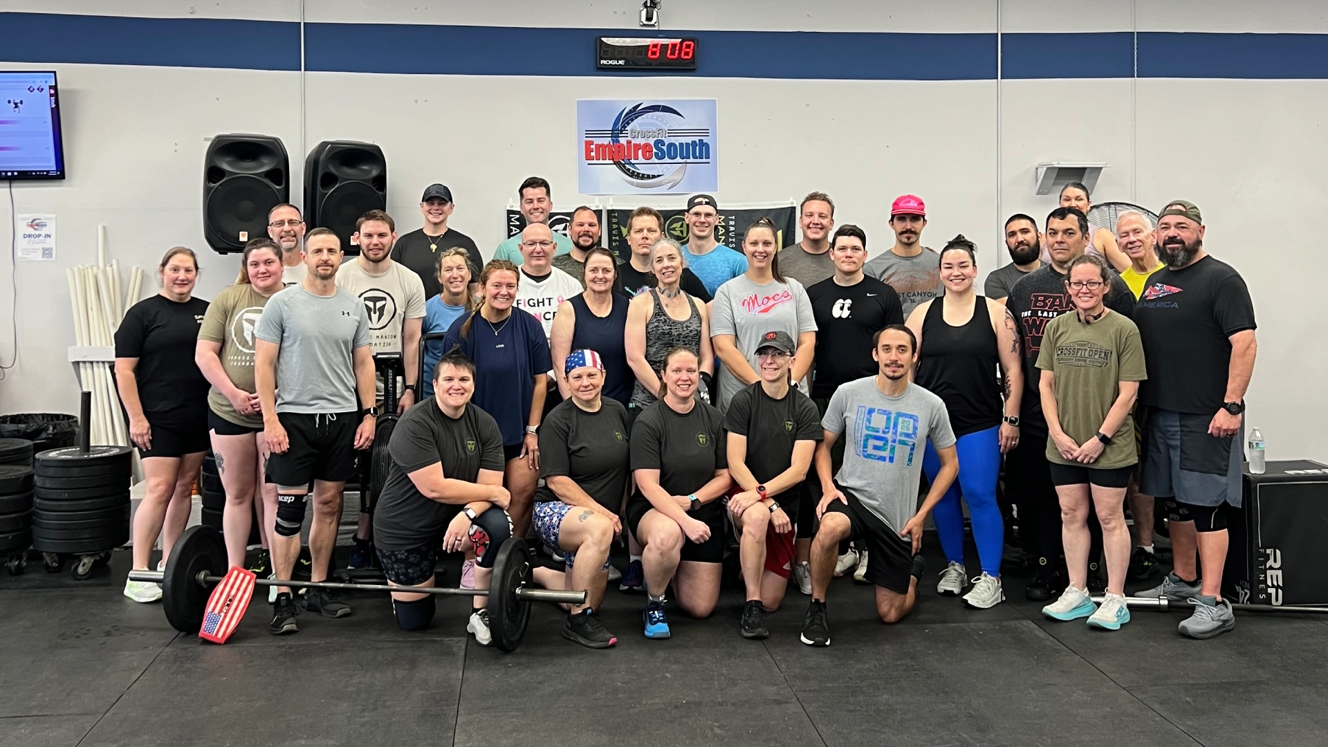 A group of people smiling and posing for a photo inside CrossFit Empire South gym in Huntsville, AL.