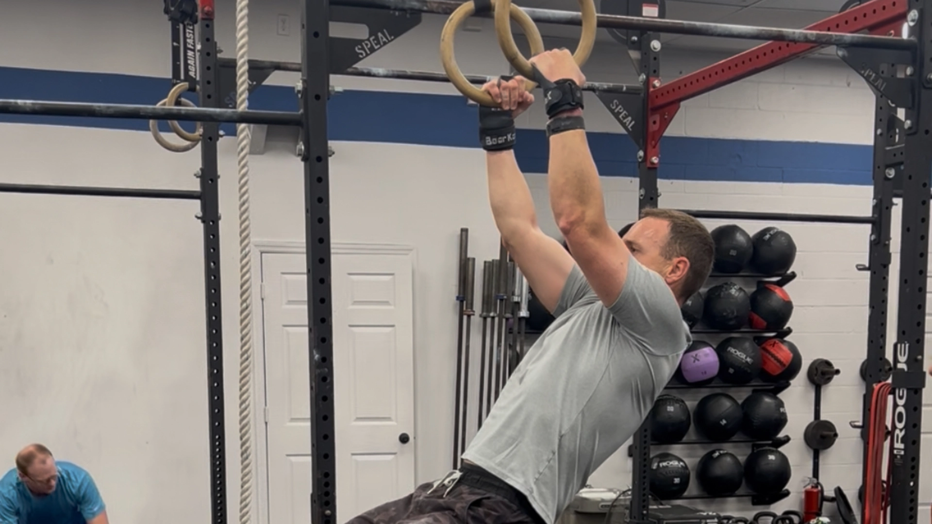 A man performs a pull-up on a gym ring at CrossFit Empire South in Huntsville, AL.