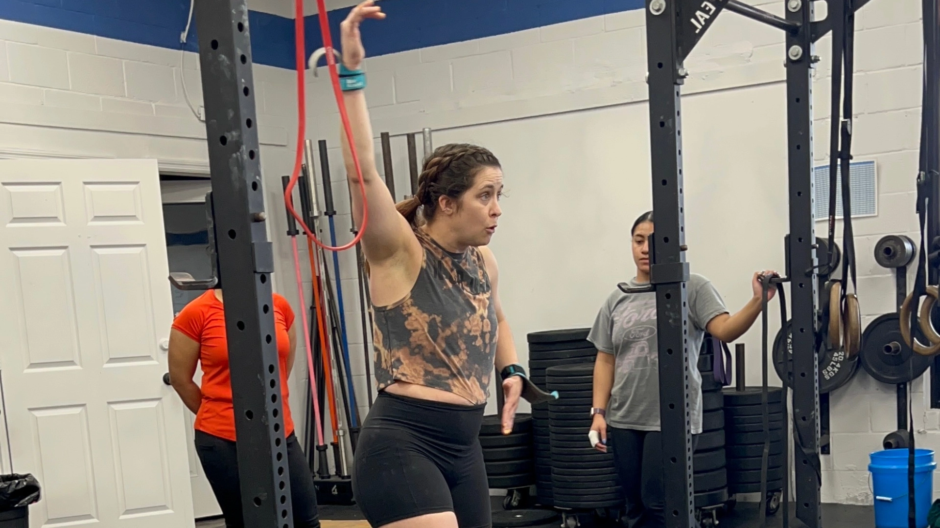 A woman performs a pull-up at CrossFit Empire South gym in Huntsville, AL, showcasing strength and determination.