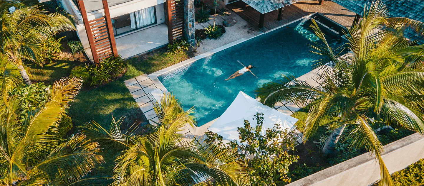Aerial view of a person bathing in a private pool in Mauritius, a symbol of relaxation and luxury with MJ Holidays.