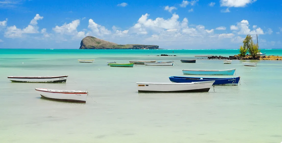 Boats floating on the turquoise waters of Mauritius, illustrating the peaceful charm of the holidays offered by MJ Holidays.