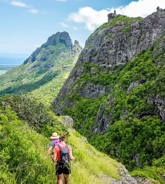 Two travelers on top of a mountain in Mauritius admiring the landscape with MJ Holidays.