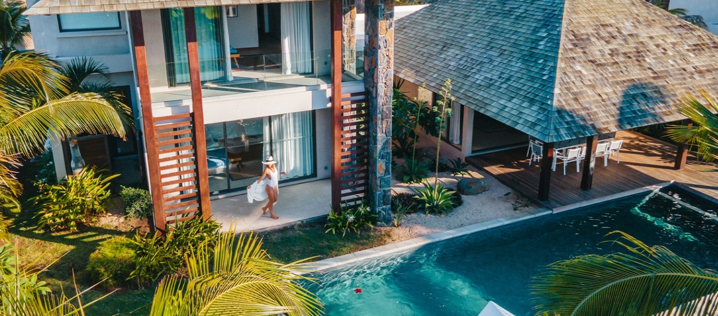 Woman relaxing by the pool at Elegance Pool Villa with MJ Holidays in Mauritius.