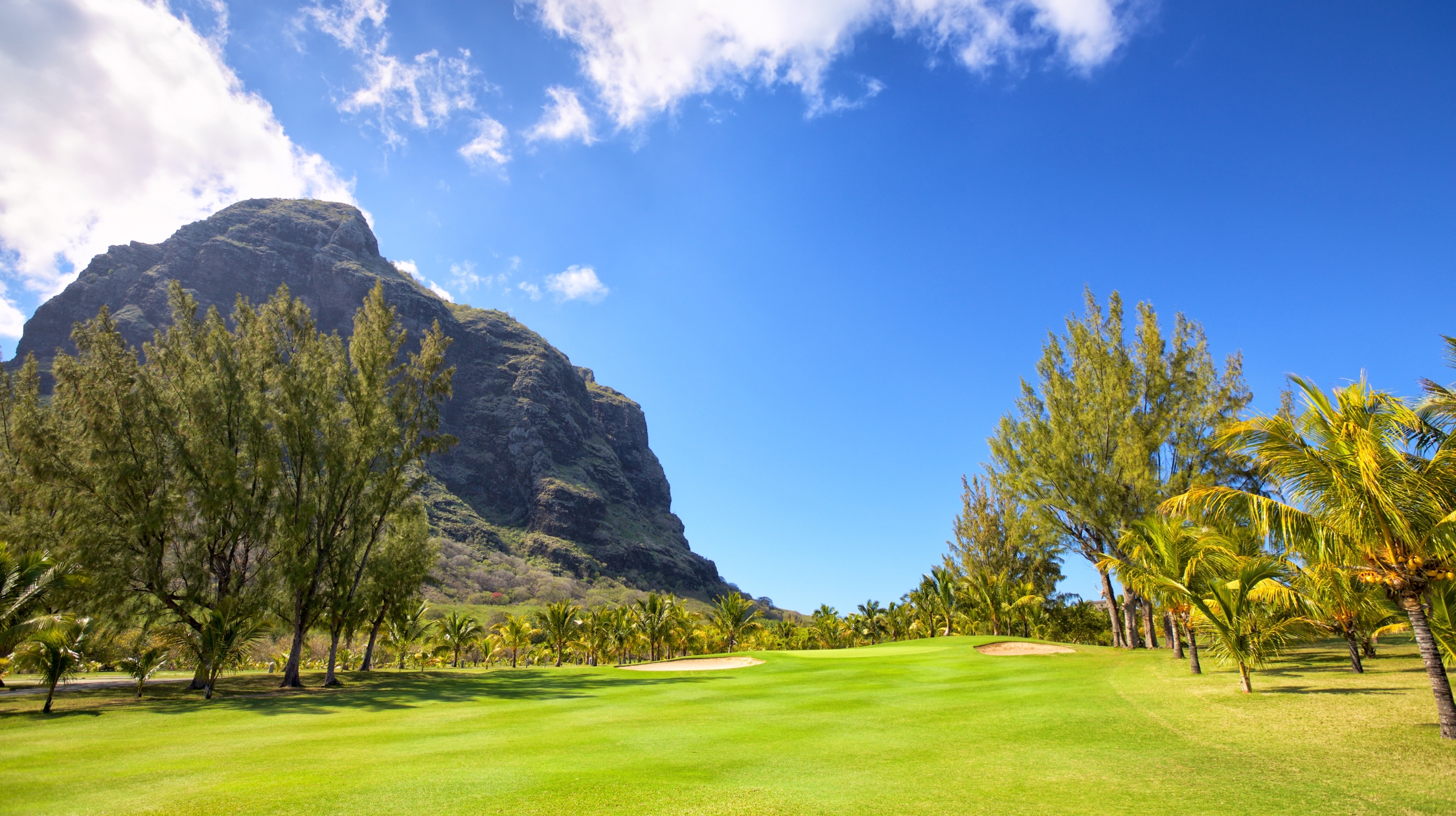 Un joueur de golf pratiquant sur un parcours tropical à l’île Maurice, une activité de plein air idéale en octobre avec MJ Holidays.