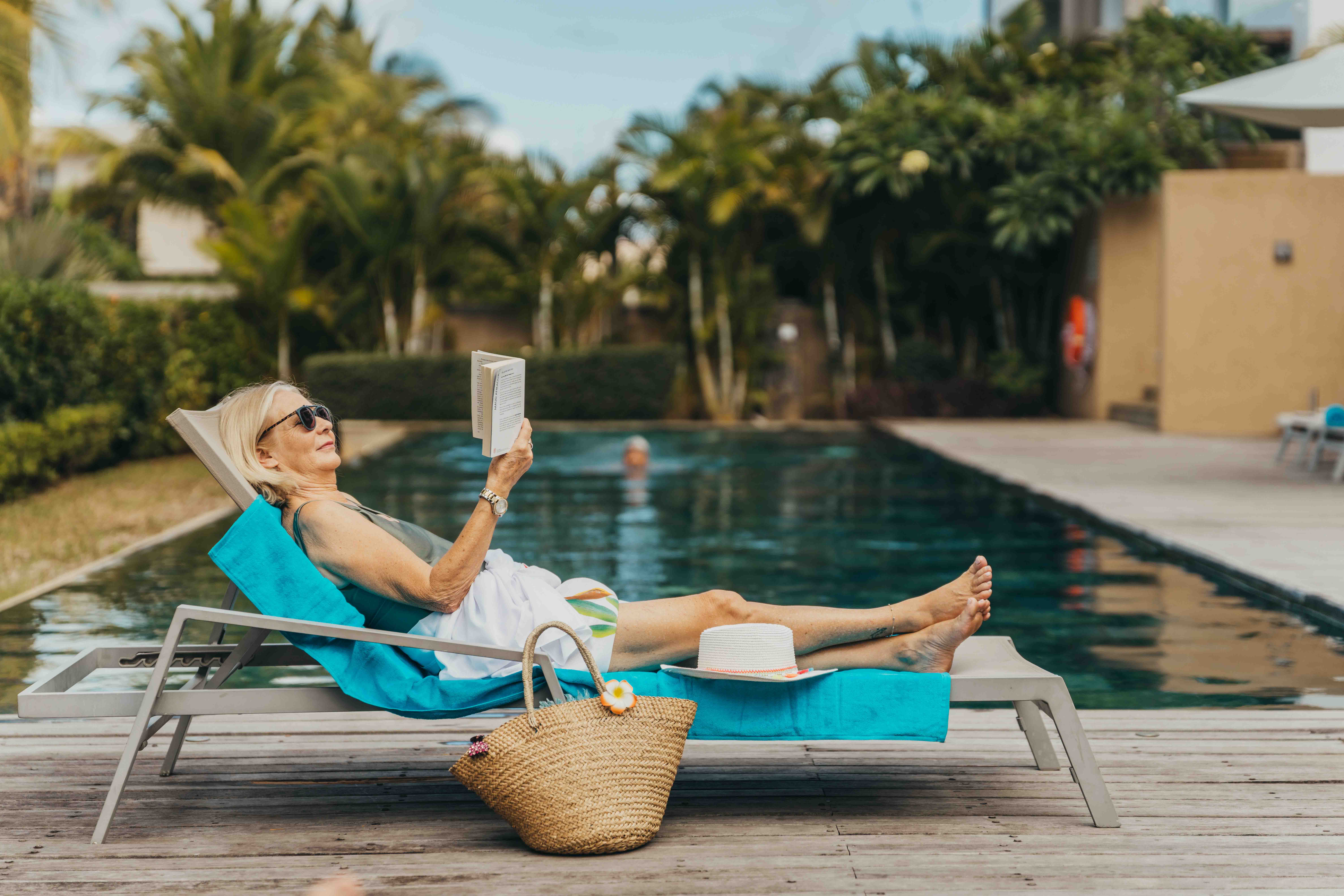 Femme se relaxant sur une bouée flamant rose dans la piscine de Mythic Suites & Villas avec MJ Holidays à l’île Maurice.