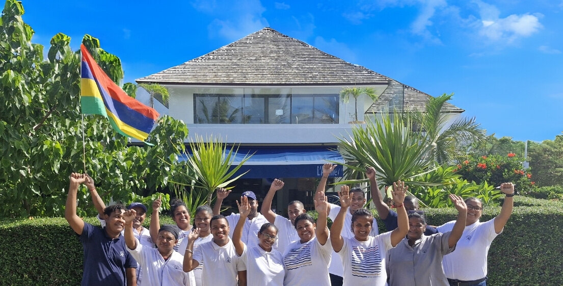 Les employés de MJ Holidays à l’île Maurice sourient en conversant en créole, illustrant l’hospitalité authentique de la culture mauricienne.