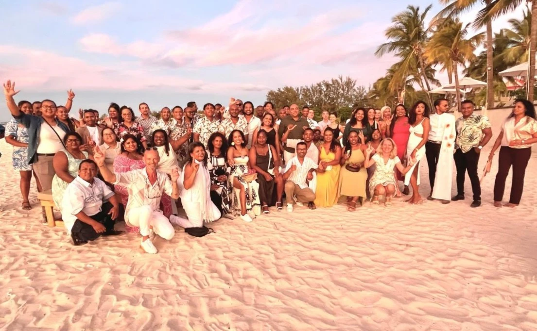 L’équipe de MJ Holidays réunie sur la plage à l’île Maurice, partageant un moment de cohésion et de bonne humeur dans un cadre tropical.
