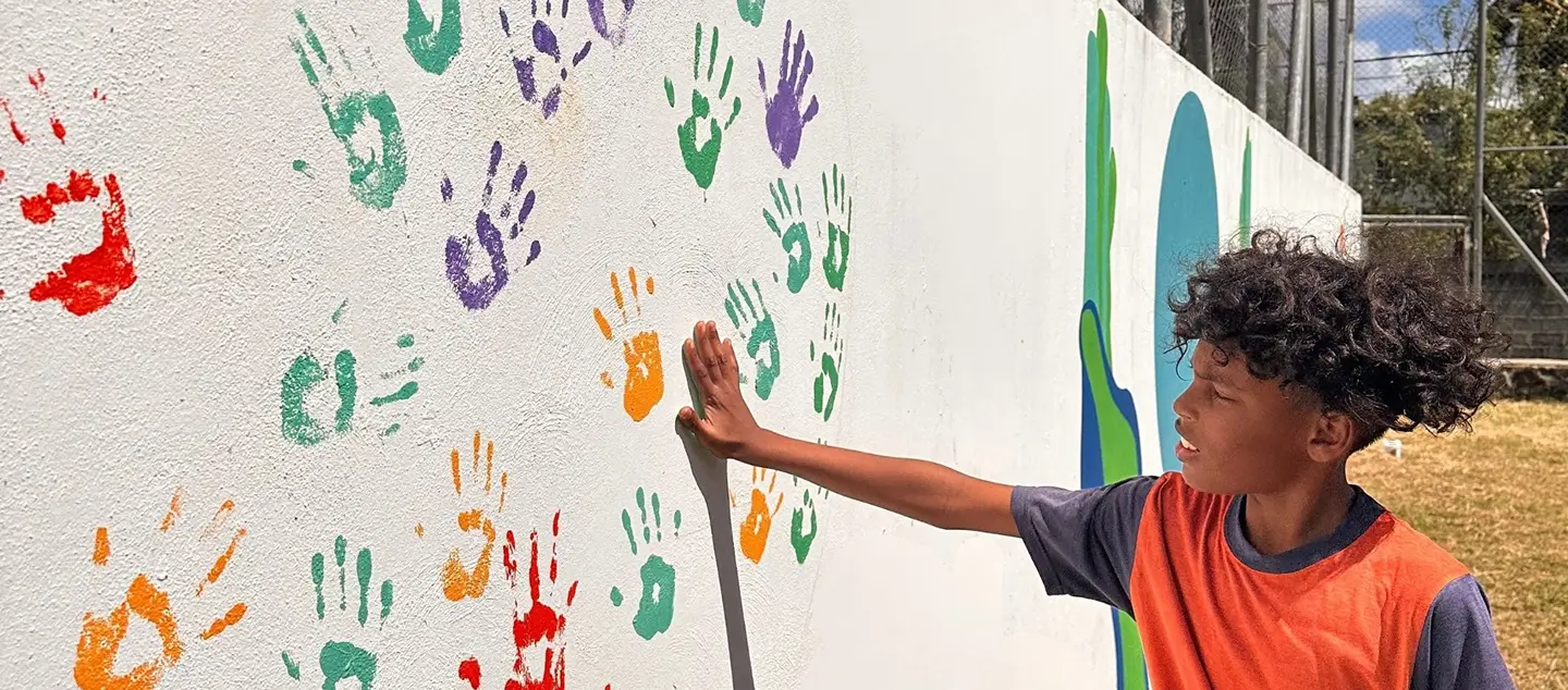 Une peinture colorée de mains sur un mur, symbolisant la créativité et la culture locale mises en avant par MJ Holidays à l’île Maurice.