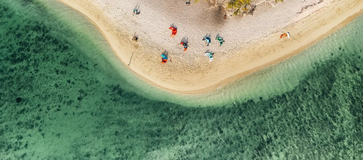 Aerial view of a white sand beach and turquoise water in Mauritius, illustrating the natural beauty of MJ Holidays destinations.