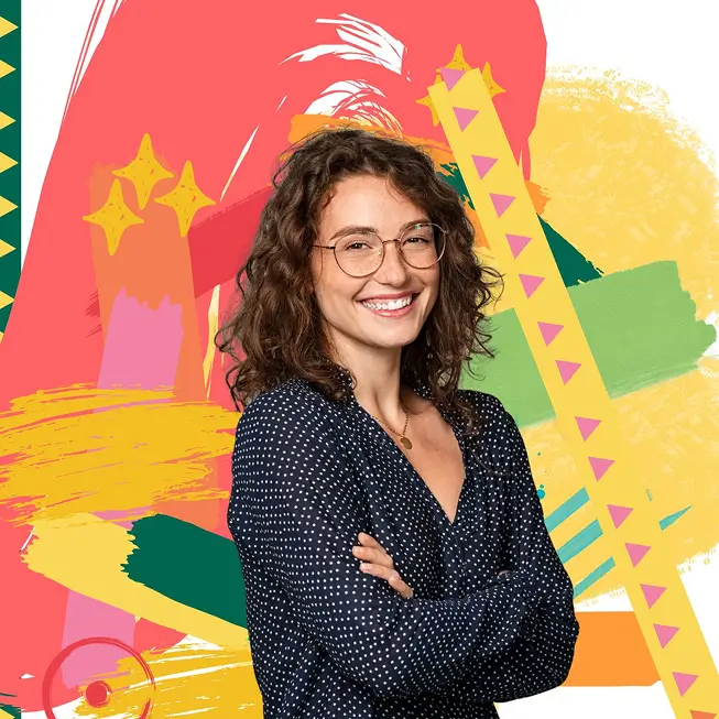 Femme souriante les bras croisés devant un mur coloré à l’île Maurice avec MJ Holidays.