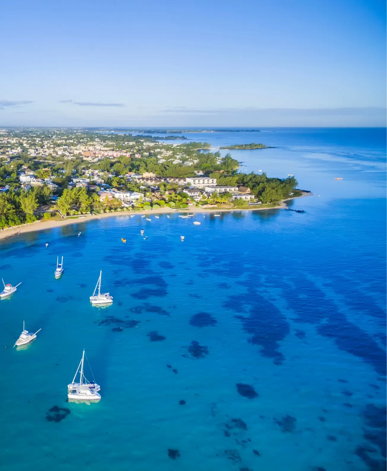 Vue aérienne des eaux turquoise de Grand Gaube parsemées de bateaux, expérience signée MJ Holidays.
