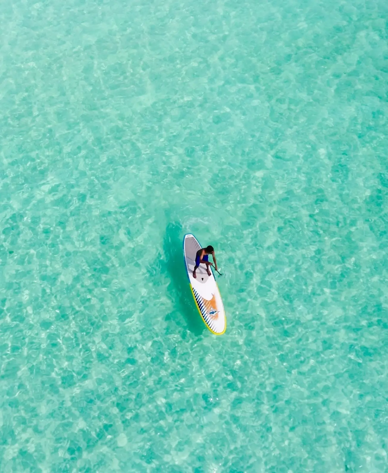 Voyageur faisant du paddle sur les eaux calmes et turquoise de Grand Gaube avec MJ Holidays.