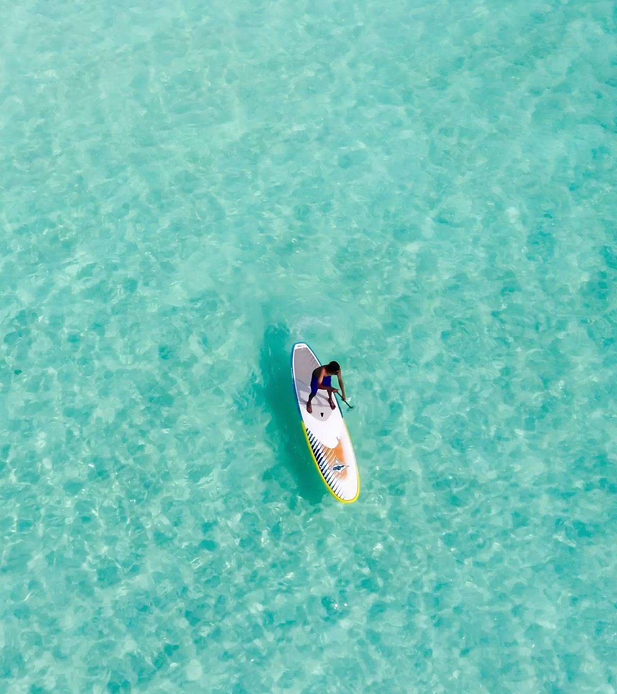 Voyageur faisant du paddle sur les eaux calmes et turquoise de Grand Gaube avec MJ Holidays.