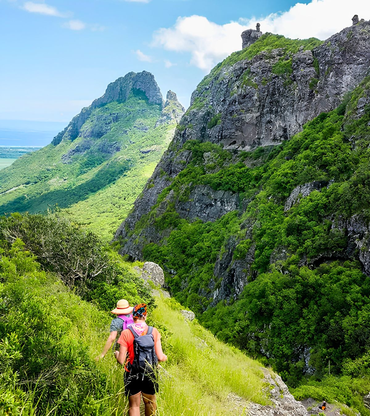 Two travelers at the top of a mountain in Mauritius admire the view with MJ Holidays.