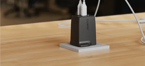 A black charging station on a wooden table.