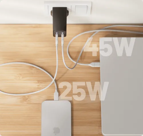 A Cuzor charger with two connected cables, one leading to a laptop and one to a phone.