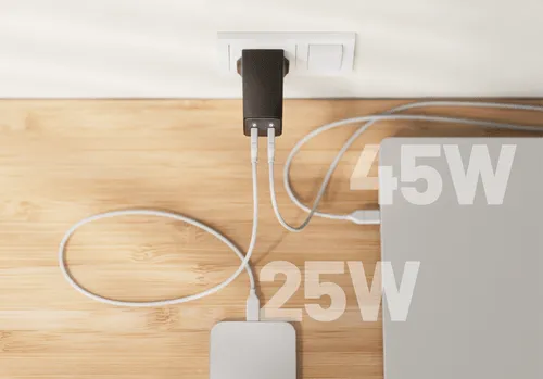 A Cuzor charger with two connected cables, one leading to a laptop and one to a phone.