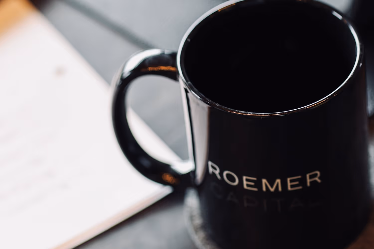 A black coffee mug with the word Roemer on it.
