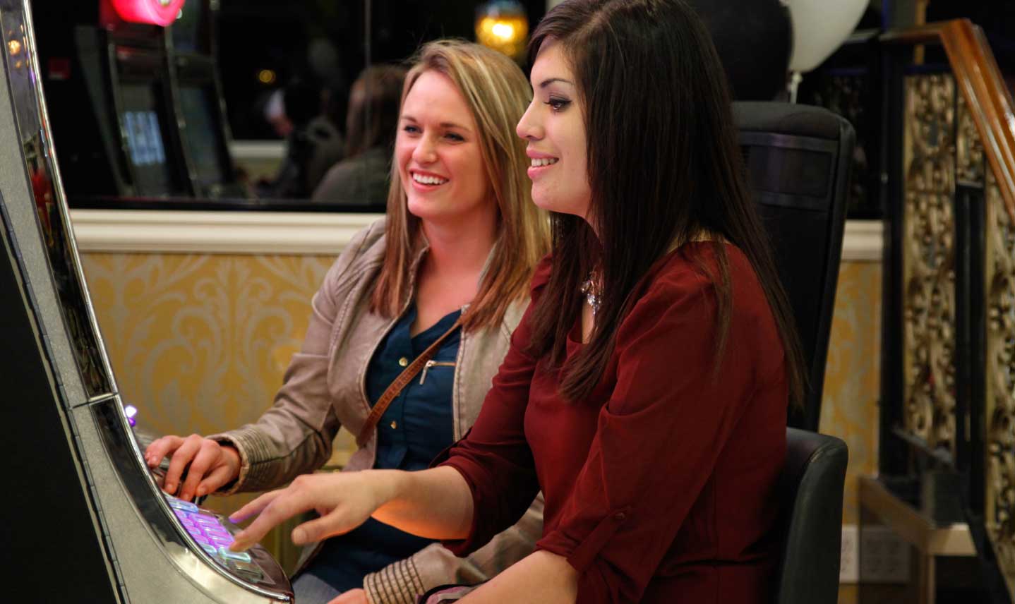 two ladies playing slot machines