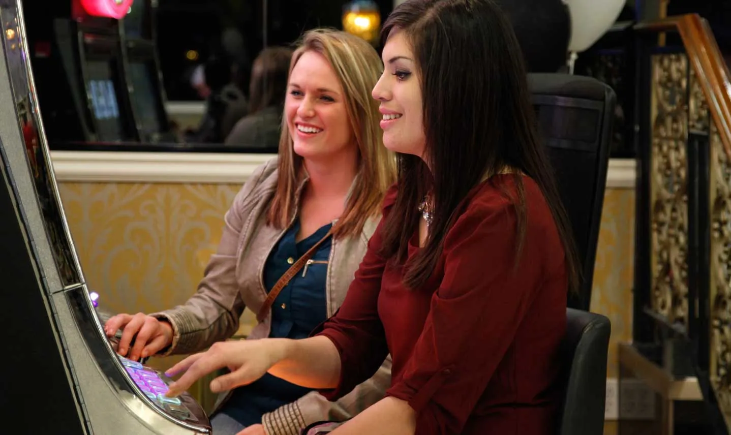 two ladies playing slot machines