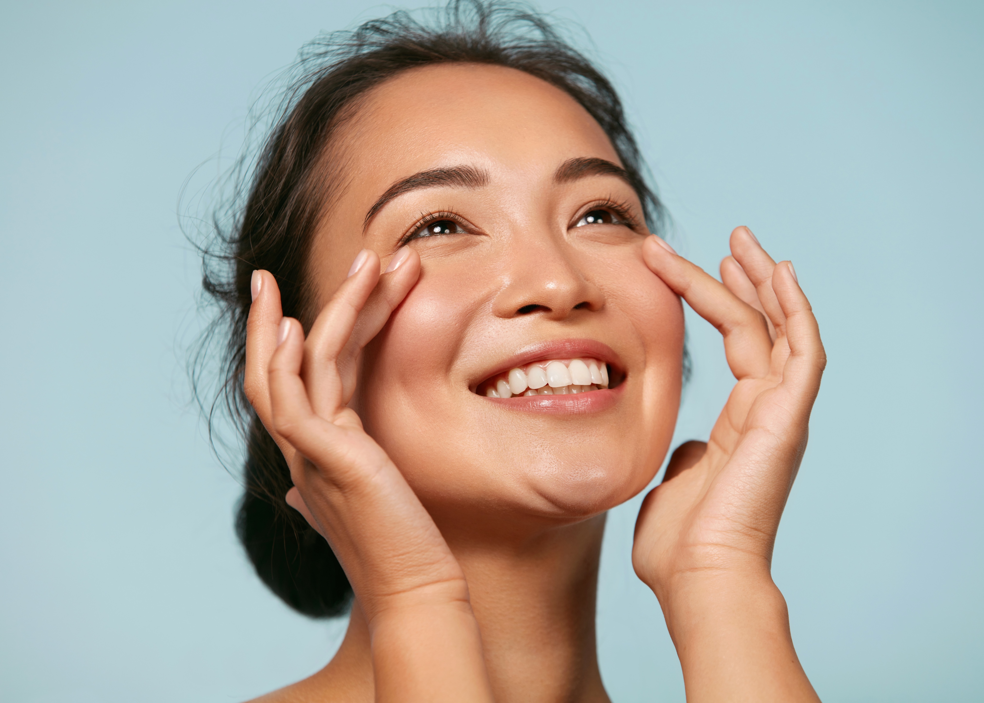 woman touching face blue background