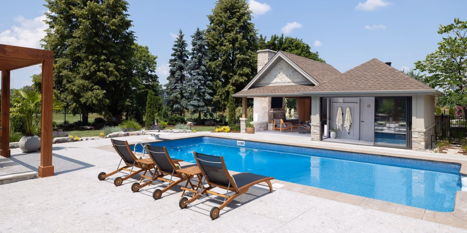 Backyard swimming pool with lounge chairs after a Pioneer Craftsmen home addition.