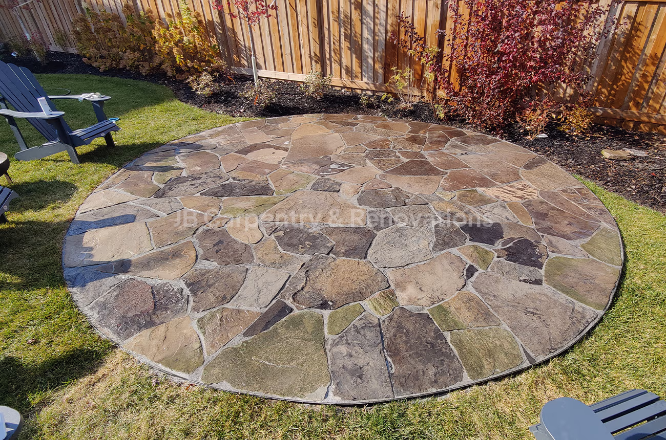 Custom circular stone patio featuring natural flagstone and detailed masonry work — outdoor renovation by JB Carpentry & Renovations.