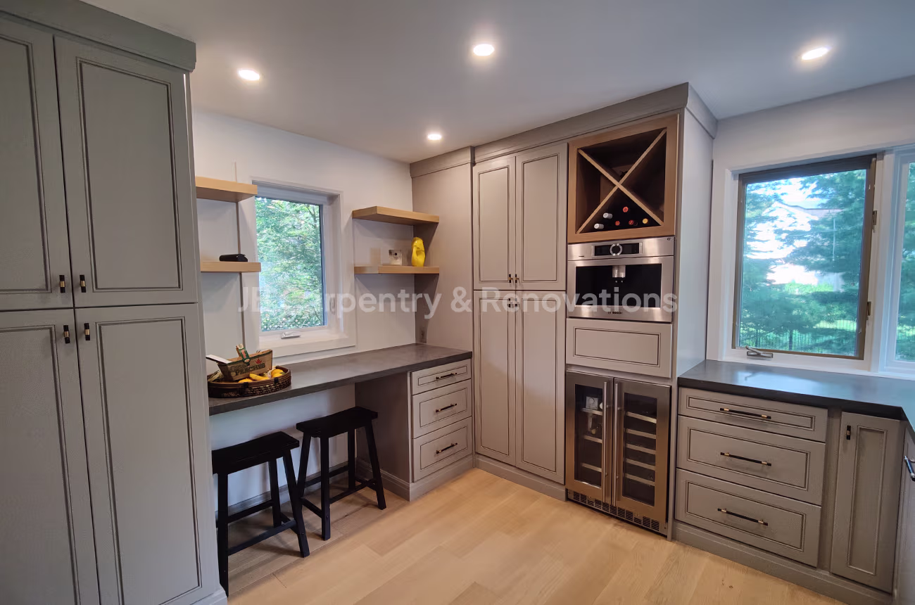 Built-in beverage station with custom cabinetry, wine storage, and integrated workspace — JB Carpentry & Renovations.