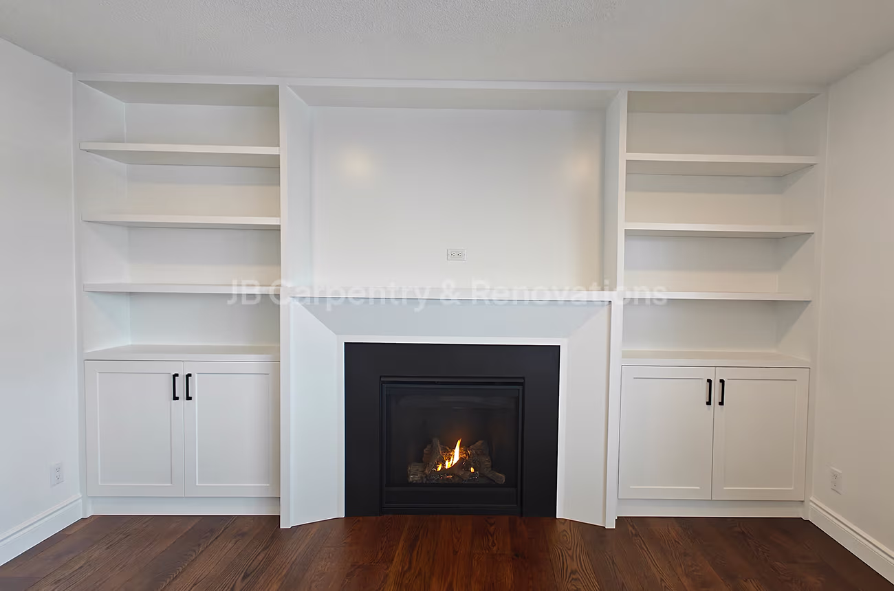 Built-in white shelving and fireplace feature wall – Full wall unit with white shaker cabinets, open shelving, and a central fireplace with black stone surround.
