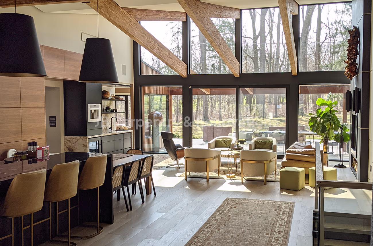 Open concept kitchen and living area with exposed beams – Contemporary great room with wood beams, expansive glass windows, and open layout connecting kitchen and living spaces.