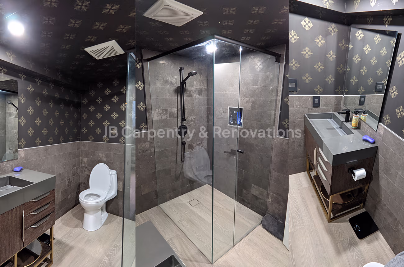 Modern dark-themed bathroom with walk-in shower – Stylish bathroom featuring patterned wallpaper, dark tiles, and a glass shower enclosure.