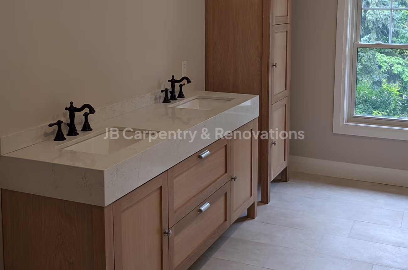 Traditional wood vanity bathroom with double sinks – Warm and inviting bathroom with natural oak cabinetry, white stone countertop, and matte black faucets beneath a bright window.