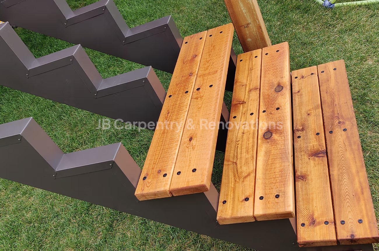 Exterior staircase with steel framing and cedar treads – Close-up of outdoor stairs showing powder-coated steel stringers and freshly finished cedar steps.