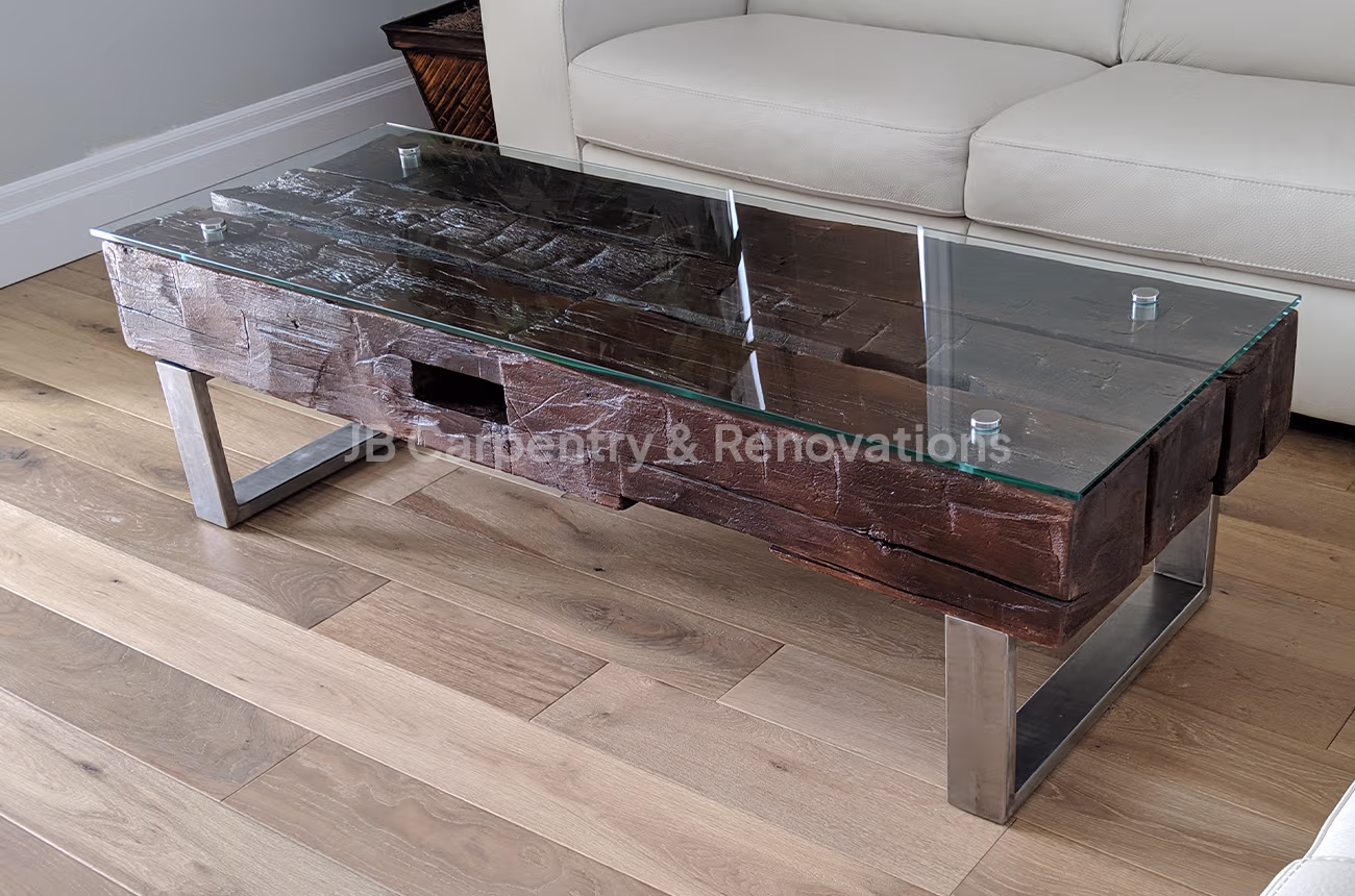 Rustic coffee table with glass top and steel legs – Reclaimed wood coffee table with thick glass surface and modern stainless-steel legs.