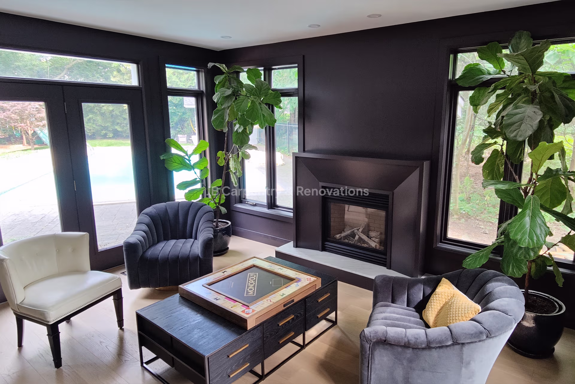 Custom dark fireplace surround in modern sitting area – Cozy living space with matte black fireplace surround, natural light, and contemporary furniture.