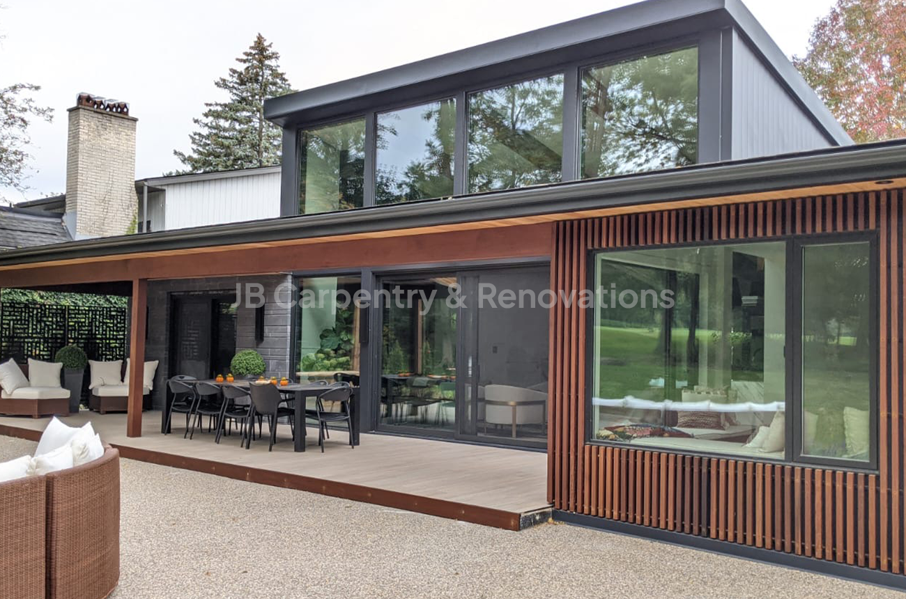 Modern new build home with wood siding and glass exterior – Contemporary custom home featuring rich wood cladding, floor-to-ceiling windows, and a spacious covered patio area.