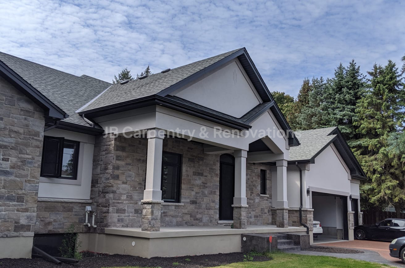 Luxury bungalow new build with stone façade and gabled roof – Sophisticated home design combining arched windows, detailed masonry, and contrasting roof lines.