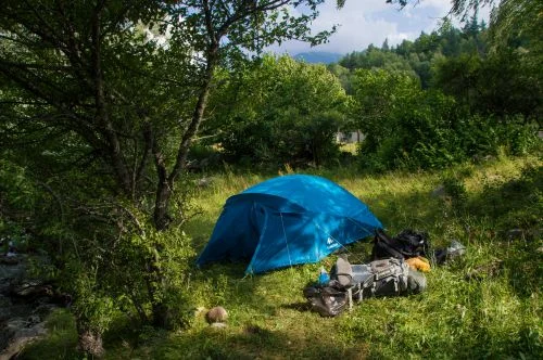 Tente bleue installée dans un paysage de campagne
