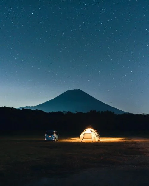 Bivouac de nuit au Japon avec le Mont Fuji se détachant du ciel au lointain