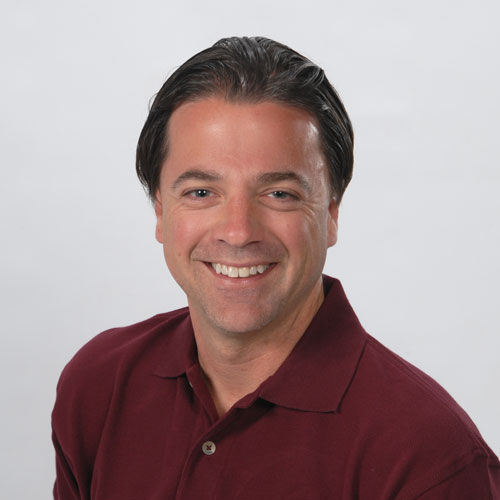 Man in maroon button down polo with jet black hair. Benjamin Joerg, real estate & buyers agent, team member of The Homebuyers
