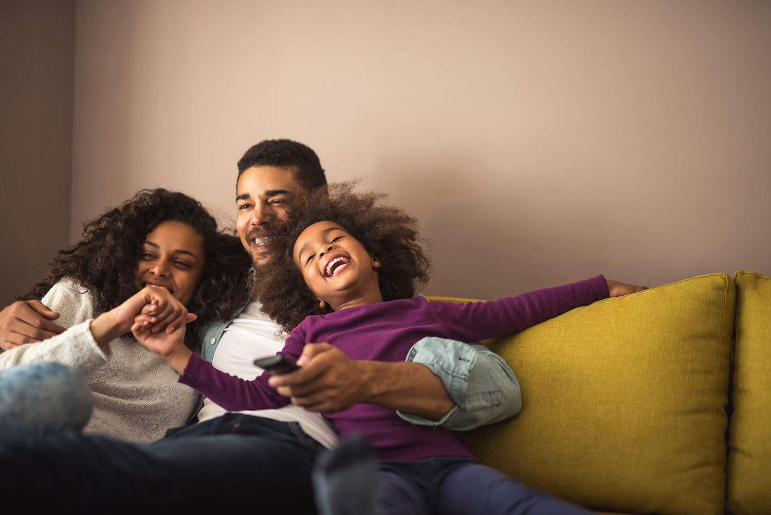 Happy family relaxing on the couch in their new home that was purchased with Minnesota exclusive buyer agents, The Homebuyers