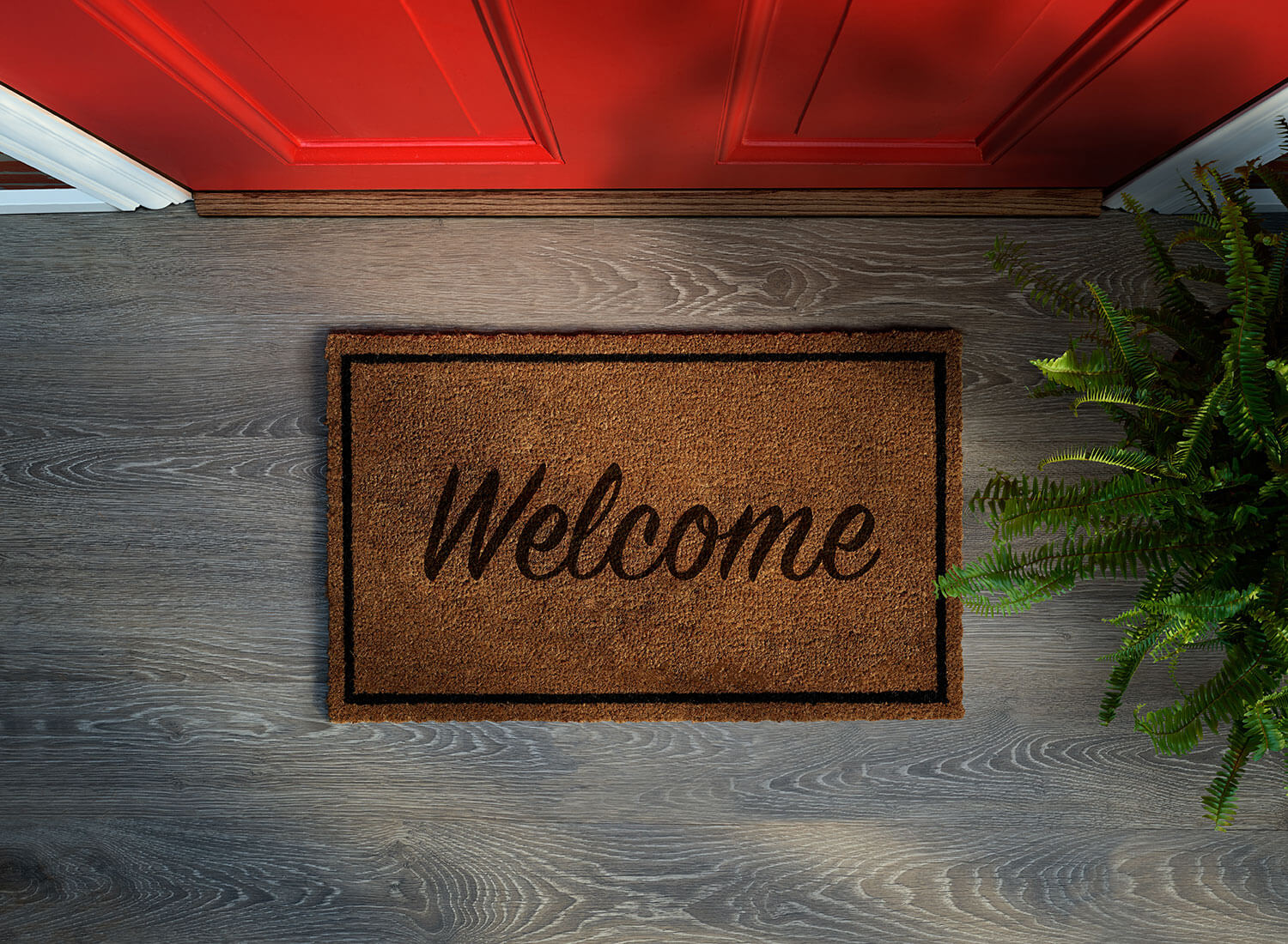 Welcome mat in front of red door. Buying a house can be complicated, let The Homebuyers help you find your dream home | MN EBA