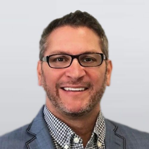 Photo of man with glasses, button down & suit jacket. Ron Jensrud, real estate & buyers agent, team member of The Homebuyers.