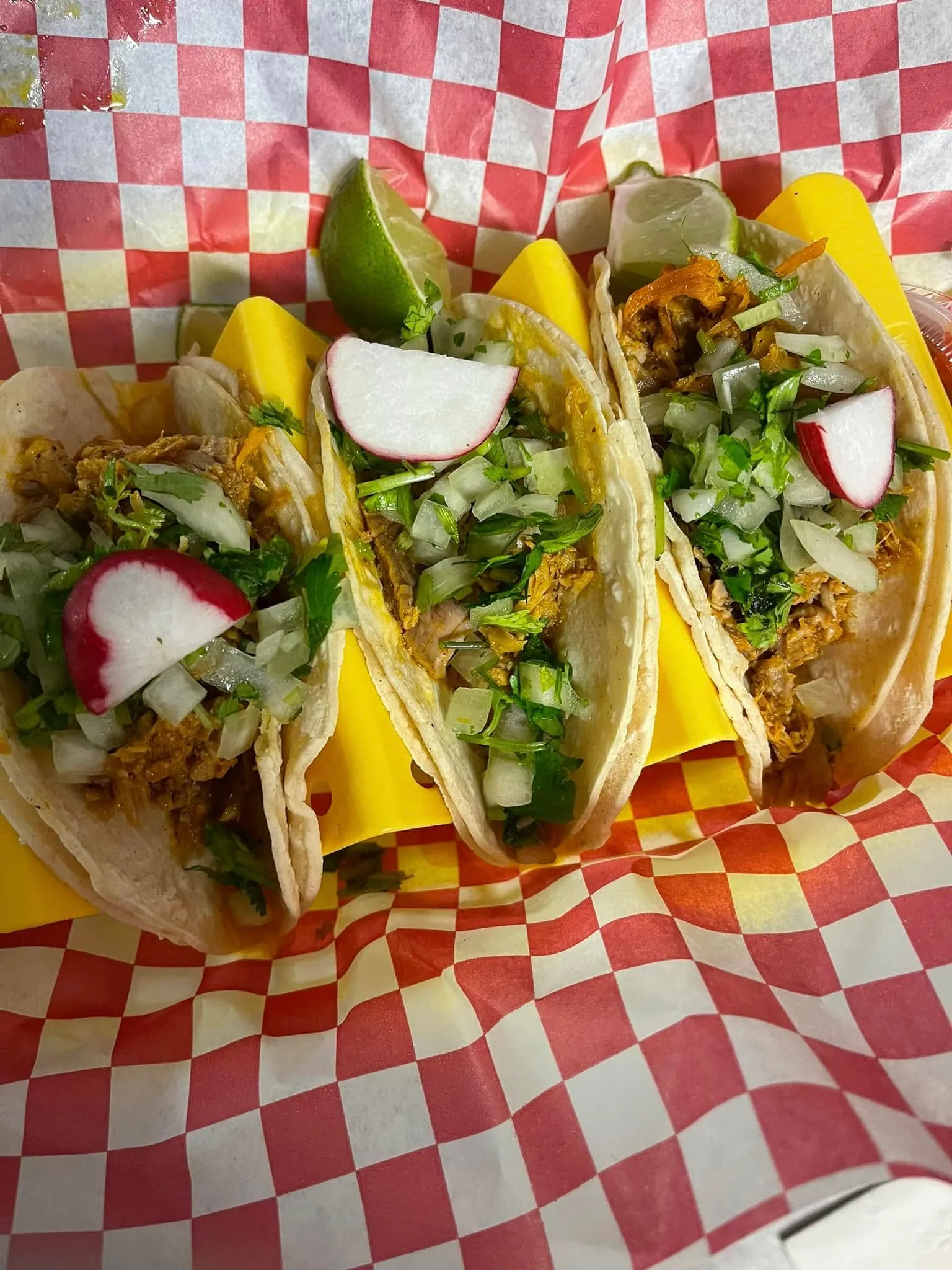 Three delicious tacos arranged neatly on a paper tray, ready to be enjoyed.