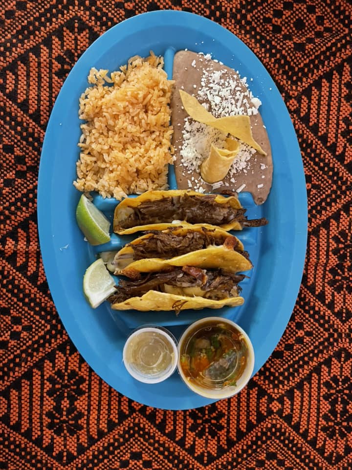 A blue plate filled with tacos, rice, and beans, showcasing a colorful and appetizing meal.