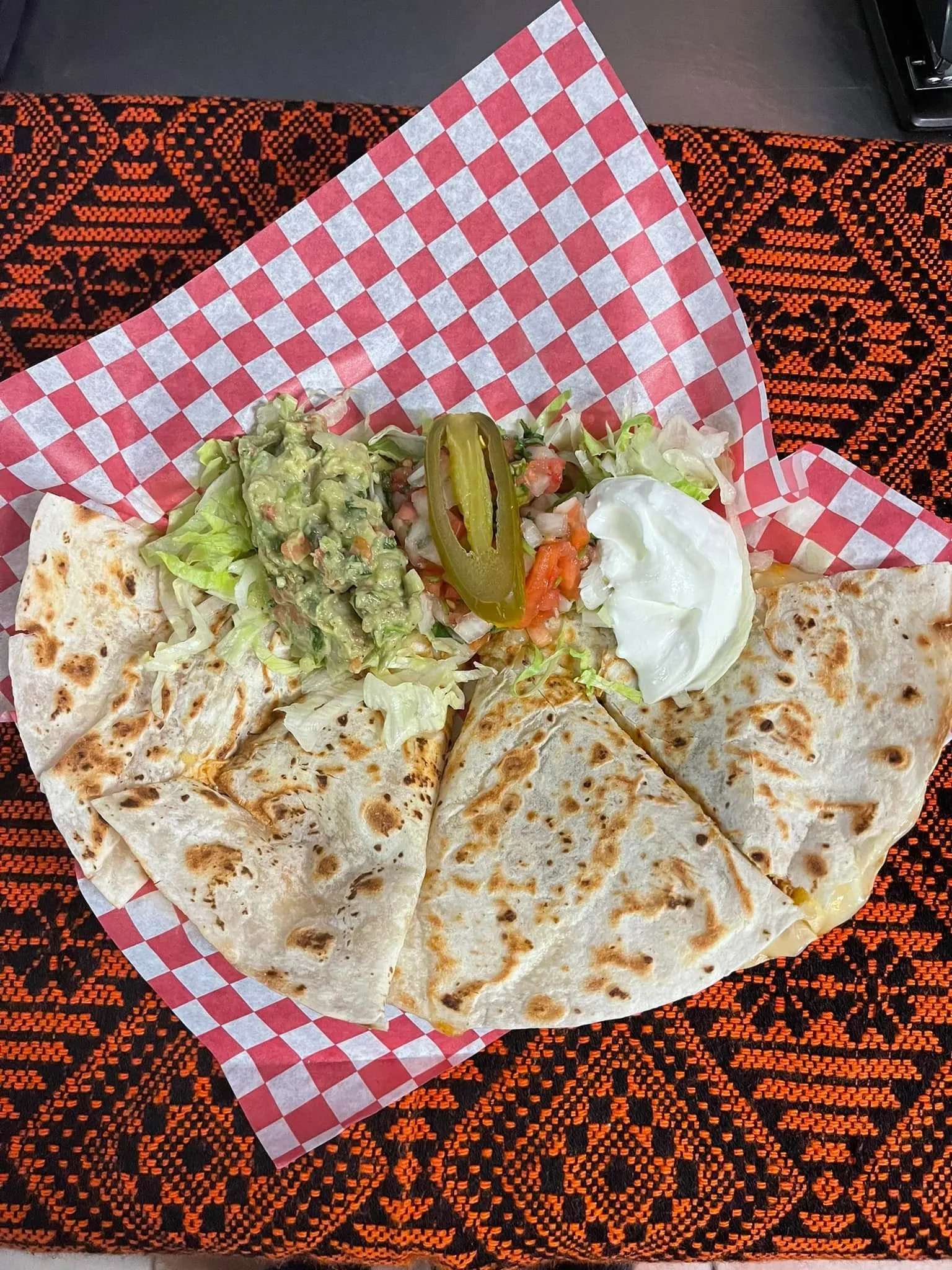 A cheesy quesadilla filled with fresh lettuce, diced tomatoes, and a side of vibrant salsa.