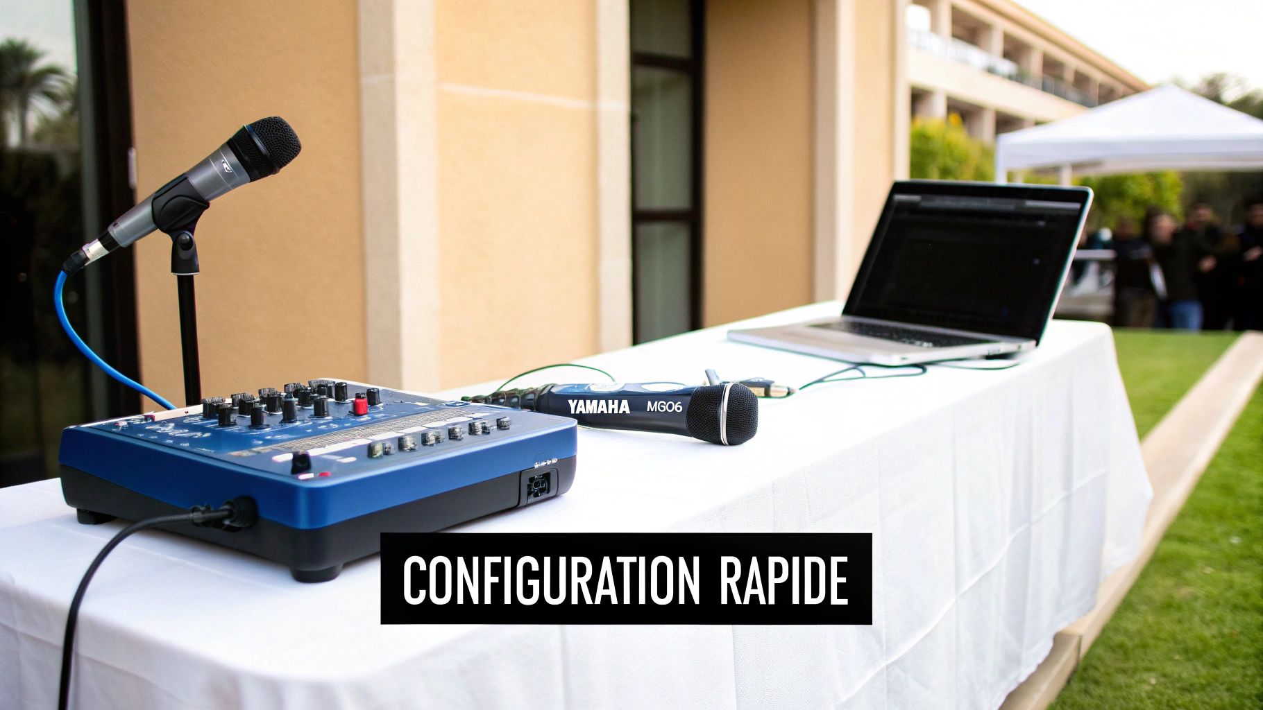 Configuration audio rapide pour événement extérieur avec mixeur Yamaha, microphones et ordinateur portable sur une table.