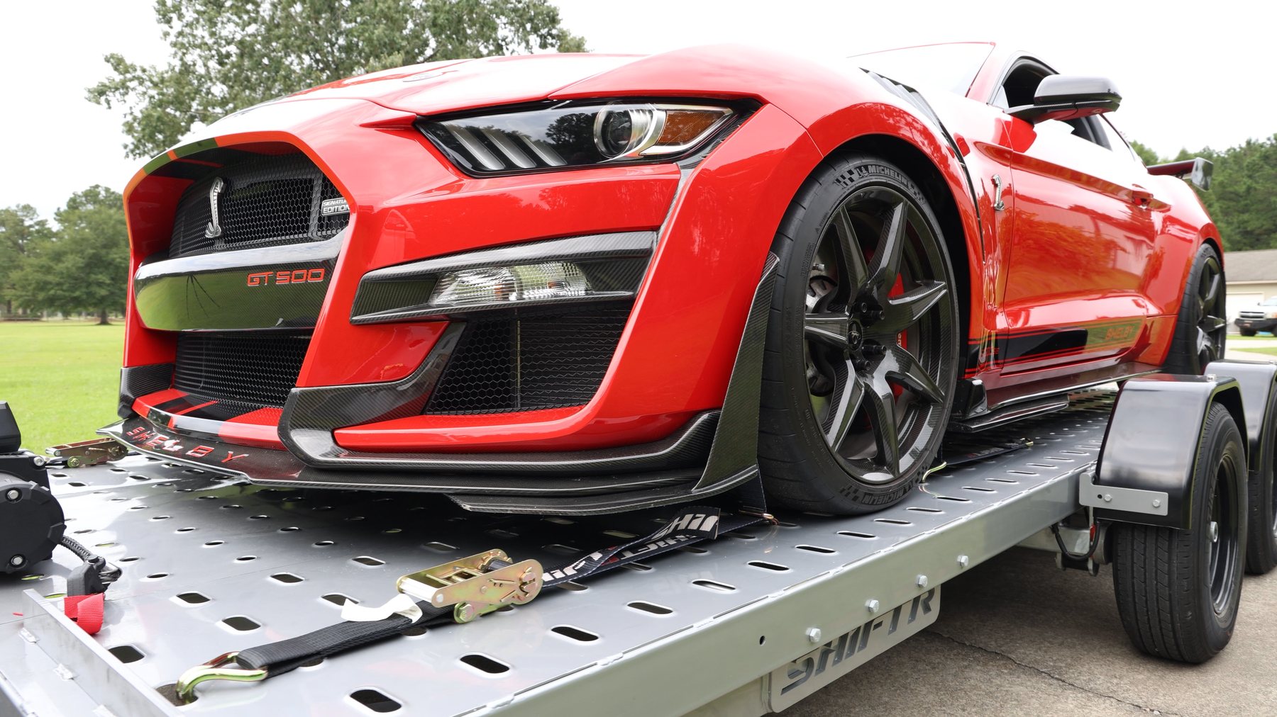 Front three quarter view of a red Shelby GT500 strapped to a SHIFTR trailer
