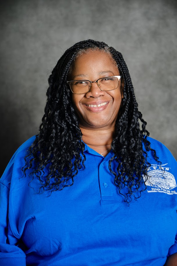 Staff member Susan Pride smiling in blue school polo