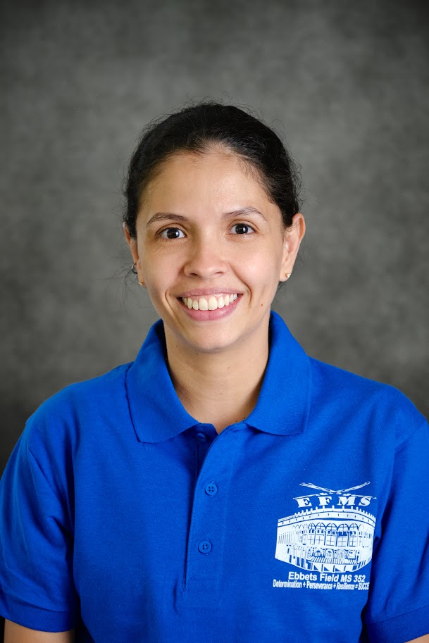 Ms Figueroa smiling in Ebbets Field MS 352 blue polo